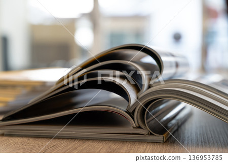 Education and research books and magazine pages stacked on desk, representing learning, reading, studying and publishing for editorial design. Education and research books and magazine pages stacked on desk, representing learning, reading, studying and publishing for editorial design. 136953785