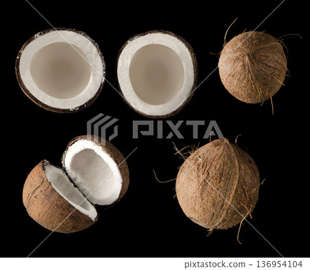 Coconut divided into two equal parts, view from the top, on a black background in isolation, collage Coconut divided into two equal parts, view from the top, on a black background in isolation, collage 136954104
