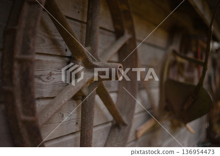 Old Wooden Wagon Wheel on Rustic Barn Wall Vintage Farm Detail Old Wooden Wagon Wheel on Rustic Barn Wall Vintage Farm Detail 136954473