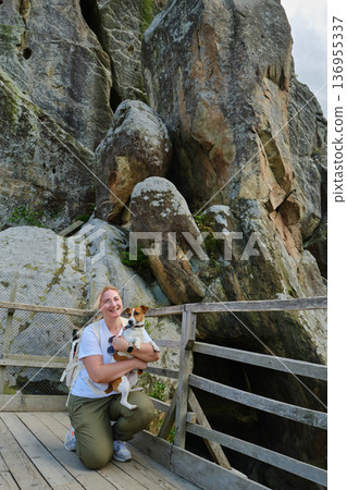 Woman Hiking with Dog on Mountain Trail 136955337