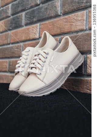 Fresh beige leather sneakers without brand marks displayed. For design templates online shops and sustainability-themed marketing. Clean blank sneakers 136955368