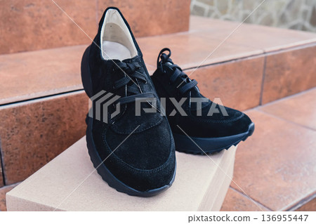 Elegant black leather womens shoes blank product for branding displayed on recycled cardboard box. New casual female sneakers no-brand footwear e-commerce. No logo product Elegant black leather womens shoes blank product for branding displayed on recycled cardboard box. New casual female sneakers no-brand footwear e-commerce. No logo product 136955447