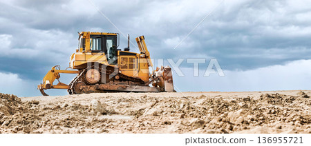 A powerful bulldozer stands at the construction site, ready to perform excavation work. Construction equipment rental A powerful bulldozer stands at the construction site, ready to perform excavation work. Construction equipment rental 136955721