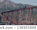 Amarube Viaduct in spring 1986, a DD51 locomotive pulling a train with snow-covered mountains in the background, April 1st. 136955848