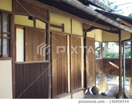 這是一棟傳統日式建築的外觀，配有木製百葉窗和麵向花園的陽台。 136956554