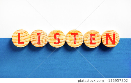 Listen symbol. Concept word Listen on beautiful wooden circles. Beautiful blue and white background. Business education listen concept. Copy space. Listen symbol. Concept word Listen on beautiful wooden circles. Beautiful blue and white background. Business education listen concept. Copy space. 136957802