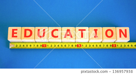 Education symbol. Concept word Education on beautiful wooden blocks. Beautiful blue background. Beautiful yellow ruler. Business education concept. Copy space. 136957938