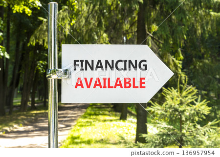Financing available symbol. Concept words Financing available on beautiful big white road sign. Beautiful green forest garden trees background. Business financing available concept. Copy space. 136957954
