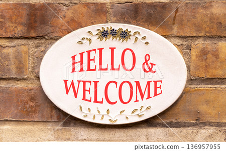 Hello and welcome symbol. Concept words Hello and welcome on beautiful big white sign plate. Beautiful old brown brick wall background. Business hello and welcome concept. Copy space. 136957955