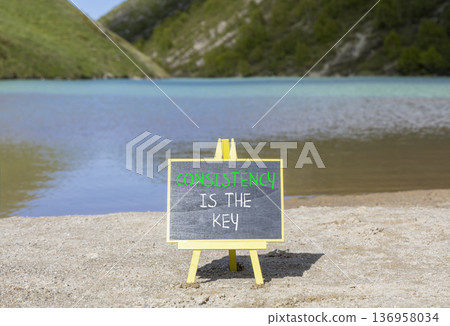 Consistency is the key symbol. Concept words Consistency is the key on beautiful blackboard. Beautiful mountain lake background. Business consistency is the key concept. Copy space. 136958034