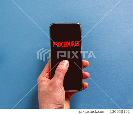 Procedures symbol. Concept word Procedures on beautiful cell phone's screen in businessman's hand. Beautiful blue background. Business procedures concept. Copy space. 136958101
