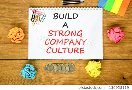Strong company culture symbol. Concept words Build a strong company culture on beautiful white note. Beautiful wooden background. Colored paper. Business strong company culture concept. Copy space. 136958119