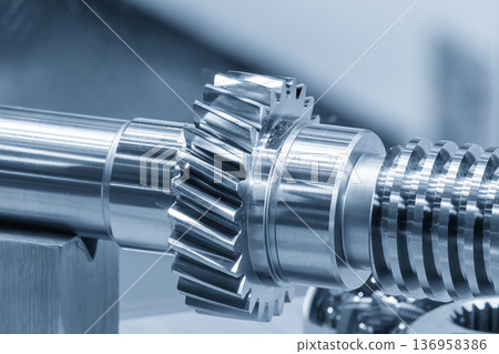 Macro shot of a high-precision automotive transmission gear shaft featuring helical teeth and spline geometry in a light blue technical setting. Macro shot of a high-precision automotive transmission gear shaft featuring helical teeth and spline geometry in a light blue technical setting. 136958386