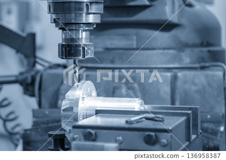 High-precision NC milling machine performing a high-speed drilling process on an aluminum alloy component in a blue-toned industrial scene. 136958387