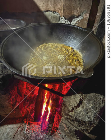Cooking Uzbek pilaf in a cast-iron cauldron. 136958591