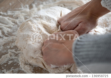 Woman kneading dough in kitchen preparing homemade bread Woman kneading dough in kitchen preparing homemade bread 136958725