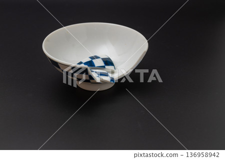 Broken rice bowl, Japanese tableware with a checkered pattern and a black background Broken rice bowl, Japanese tableware with a checkered pattern and a black background 136958942