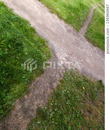 Earthen crossroads on the grass. Earthen crossroads on the grass. 136960667