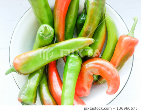 Red and green peppers in a metal plate. Red and green peppers in a metal plate. 136960673