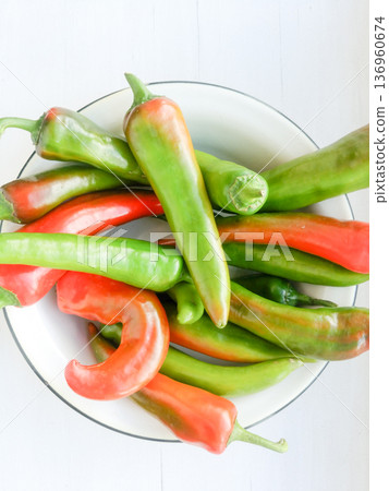 Red and green peppers in a metal plate. Red and green peppers in a metal plate. 136960674