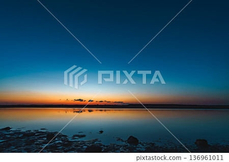 Sunrise at Gamou tidal flats, Sendai city, Miyagi prefecture. Reflections on the water surface. 136961011