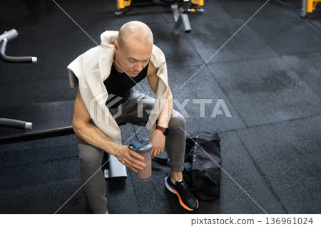 Man with protein shake after strength workout in gym Man with protein shake after strength workout in gym 136961024