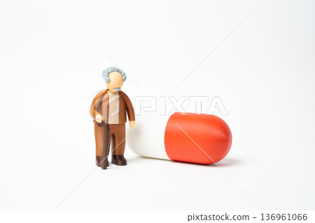 An elderly man and a medicinal capsule. Affordable medications for seniors. Access to healthcare and pharmaceutical support. Treatment cost reduction and insurance coverage An elderly man and a medicinal capsule. Affordable medications for seniors. Access to healthcare and pharmaceutical support. Treatment cost reduction and insurance coverage 136961066