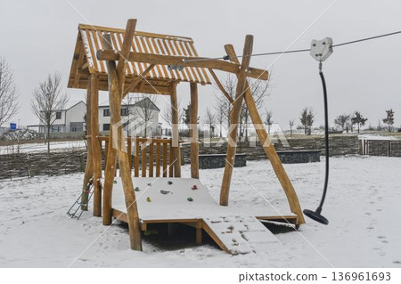Snow-covered playground and snow-covered playhouse on the children's playground. Concept of winter and winter nature. 136961693