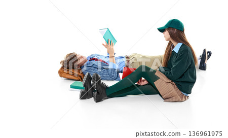 Teen students studying on floor with books isolated on white. Teen students studying on floor with books isolated on white. 136961975