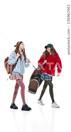 Teen girls in preppy outfits walking with golf bag isolated on white. Teen girls in preppy outfits walking with golf bag isolated on white. 136962001