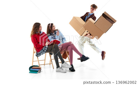 Teen students in preppy outfits reacting to boy with falling boxes isolated on white 136962002