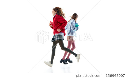 Teen girls in preppy school outfits running in opposite directions isolated on white 136962007