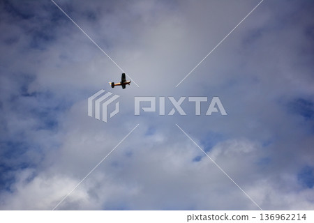 Orange airplane soaring through cloudy mexican skies 136962214