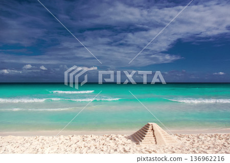 Sand pyramid on pristine mexican beach with turquoise sea Sand pyramid on pristine mexican beach with turquoise sea 136962216