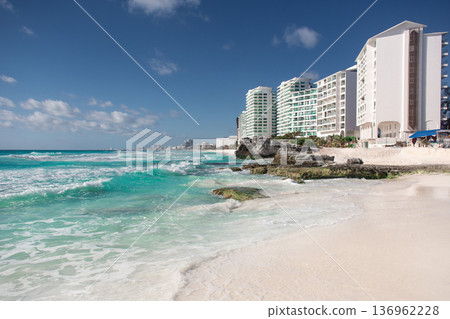 Turquoise waves washing white sand beach with modern hotels Turquoise waves washing white sand beach with modern hotels 136962228