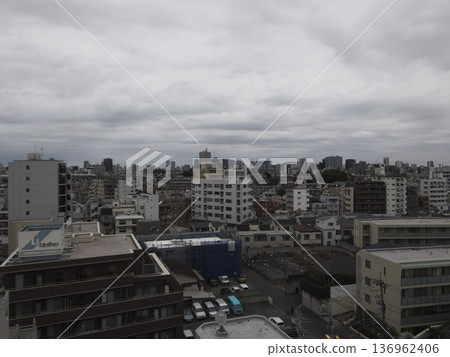 A view of the cityscape and buildings of a Japanese city under a cloudy sky A view of the cityscape and buildings of a Japanese city under a cloudy sky 136962406