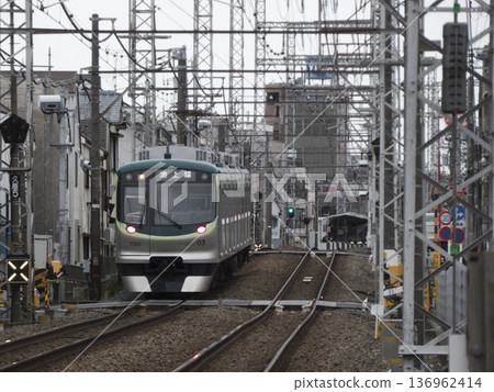 The rear view of a Tokyu Ikegami Line 7000 series train and the complex intersection of overhead power lines The rear view of a Tokyu Ikegami Line 7000 series train and the complex intersection of overhead power lines 136962414