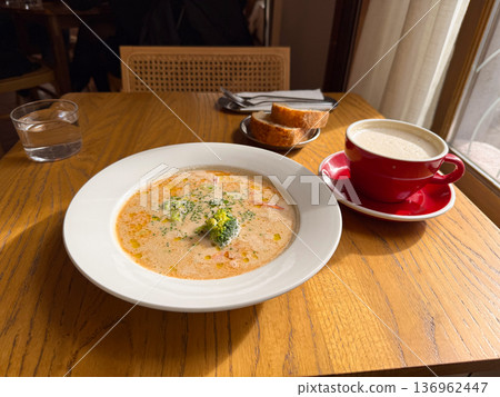 Fish cream soup with broccoli served in cafe near window. Lunch break, comfort food, healthy choice, dining ritual, cozy atmosphere Fish cream soup with broccoli served in cafe near window. Lunch break, comfort food, healthy choice, dining ritual, cozy atmosphere 136962447