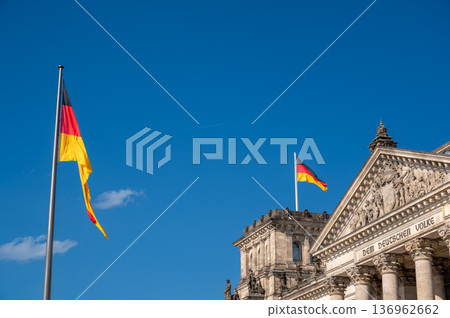 Berlin, germany, august 15, 2023. German flags waving against a clear blue sky, showing the reichstag building in berlin, representing government and democracy 136962662