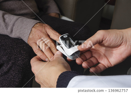a healthcare worker checking oxygen levels a healthcare worker checking oxygen levels 136962757