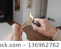 a man lights a sandalwood stick indoors 136962762