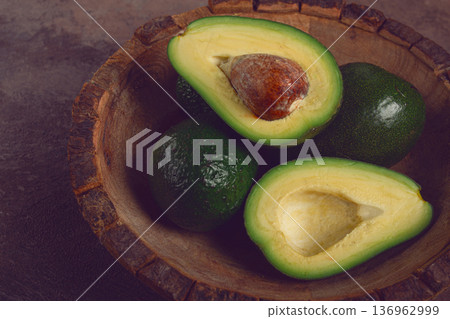 fresh, sliced avocado, in a wooden plate, top view, food background, concept, food styling 136962999