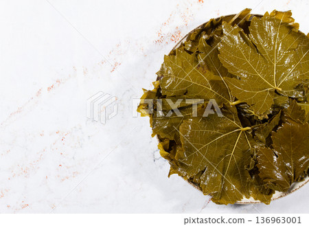 canned grape leaves, for cooking dolma, on a plate, 136963001