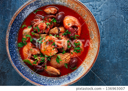 seafood in tomato sauce with olives, on a dark blue background, seafood in tomato sauce with olives, on a dark blue background, 136963007