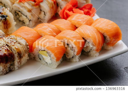 Salmon sushi rolls with cream cheese served on white plate closeup Japanese cuisine 136963316