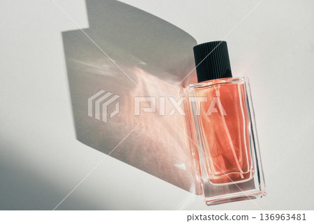 Glass perfume bottle on white background with shadow and light refraction Glass perfume bottle on white background with shadow and light refraction 136963481