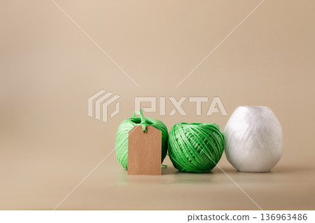 Various green and white spools of recycled polyester fiber with a blank label indicating the product's eco-friendliness. Recycling, conscious waste management Various green and white spools of recycled polyester fiber with a blank label indicating the product's eco-friendliness. Recycling, conscious waste management 136963486