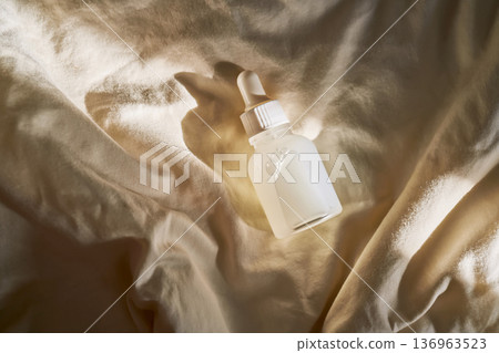 Skincare serum bottle on fabric in morning light Skincare serum bottle on fabric in morning light 136963523