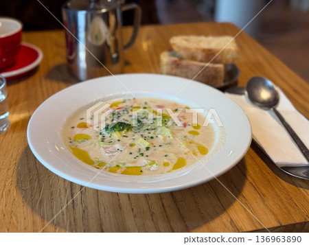 Close-up creamy vegetable fish soup with broccoli and herbs on table. Homemade cuisine, healthy nutrition and cozy lunch concept. Close-up creamy vegetable fish soup with broccoli and herbs on table. Homemade cuisine, healthy nutrition and cozy lunch concept. 136963890