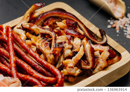 Closeup of cured meats and smoked sausages on wooden board gourmet snack assortment Closeup of cured meats and smoked sausages on wooden board gourmet snack assortment 136963914